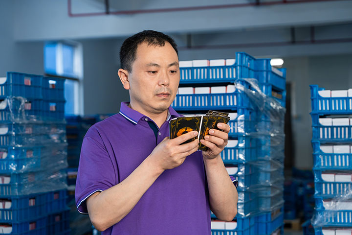 Employee conducts quality inspection of finished cards